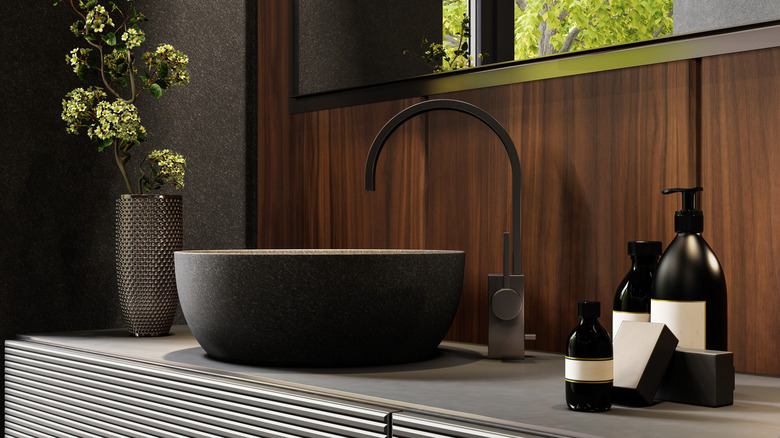 Bathroom counter with black soap dispensers and sink