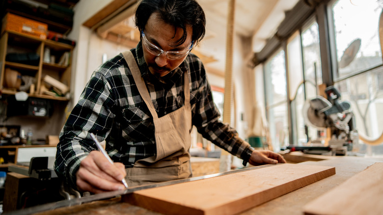 Someone measuring a wood board