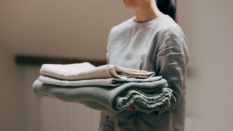 folded blankets in a women's hands