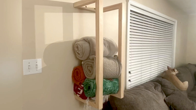 Smart wall-mounted blanket storage made from pieces of wood