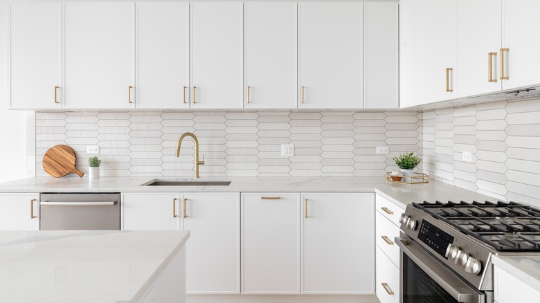 White kitchen with white cabinets and tile
