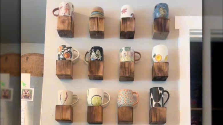 Individual mounted wood blocks on wall with coffee mugs displayed on top