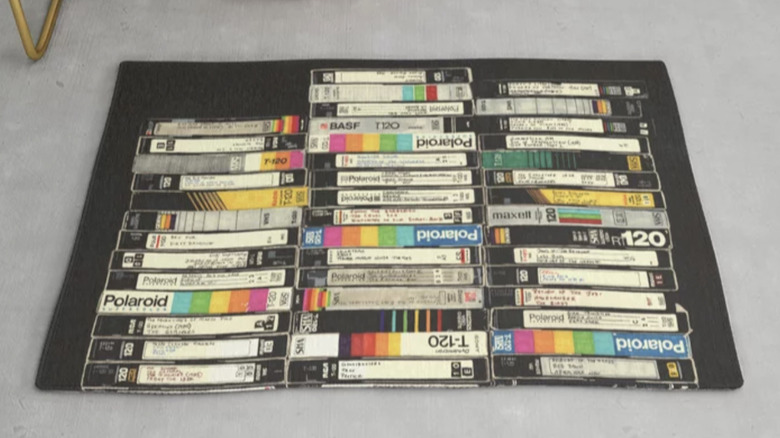 Printed rug with image of old VHS tapes stacked up on each other.