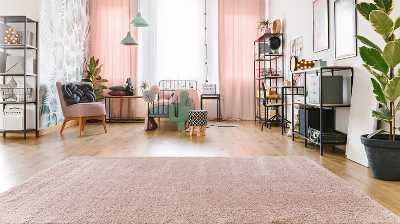Pastel decorated bedroom with pastel pink area rug.