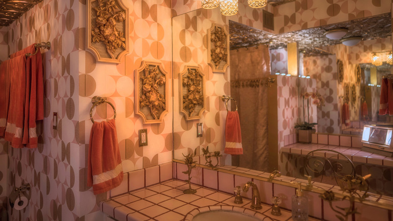 A pink and gold maximalist bathroom.