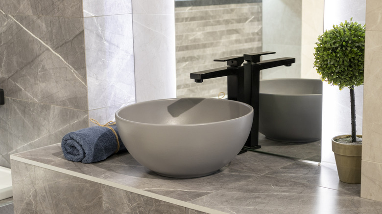 A modern gray bathroom with a vessel sink.