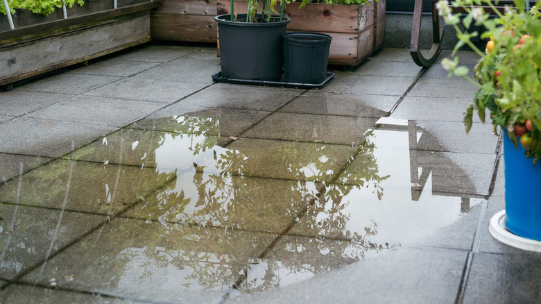A patio with rainwater pooling in the middle