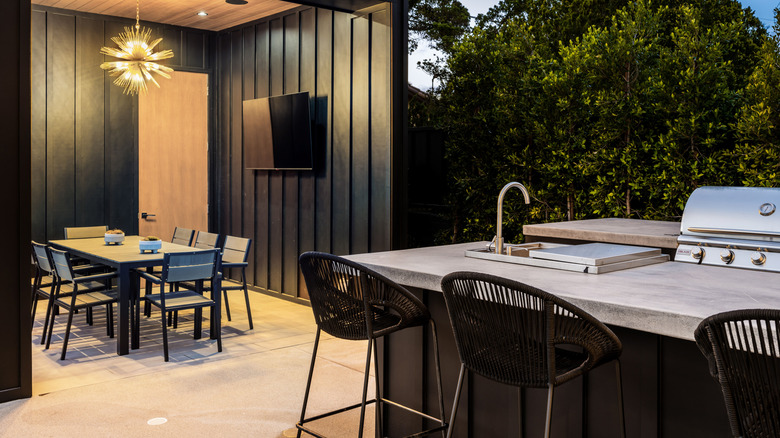 A modern back yard with a large shelter and an outdoor kitchen