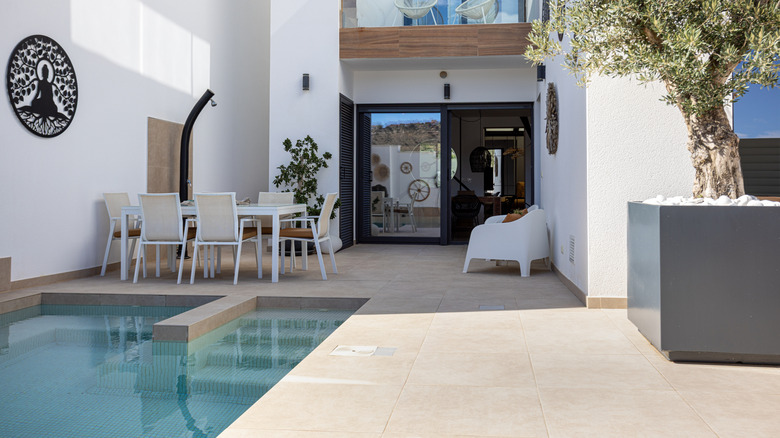 A white-walled courtyard with pool and light-colored paving