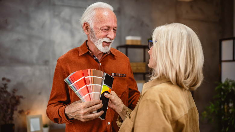 Boomer couple look at paint colors.