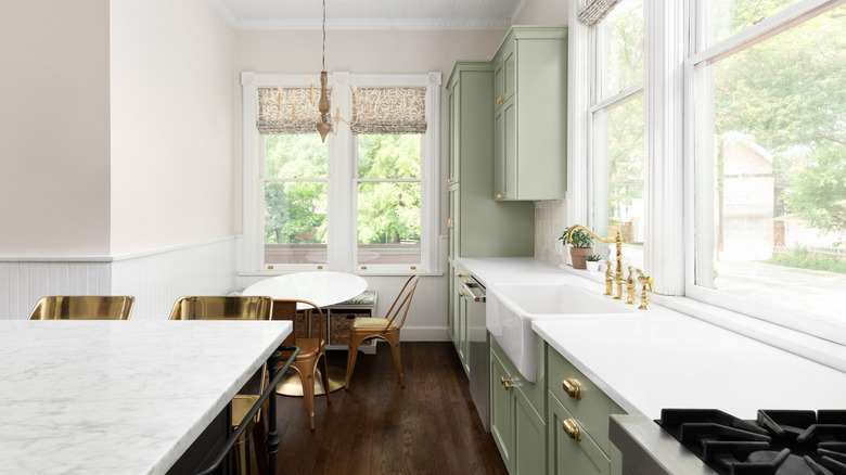 A modern farmhouse kitchen and breakfast nook with gold fixtures and furnishings