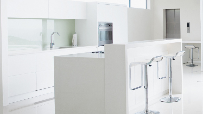 A bright white kitchen with hidden appliances.