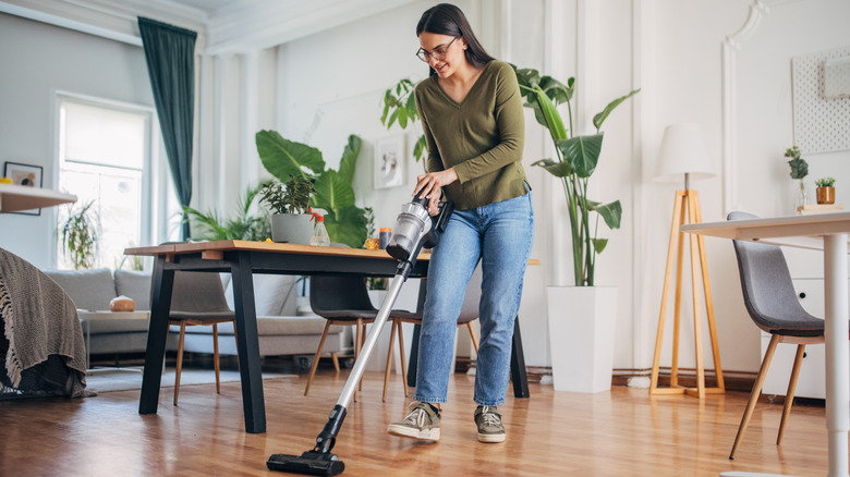 A woman vacuums her floors.