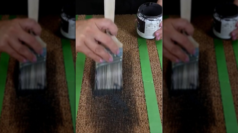 Person painting an IKEA door mat