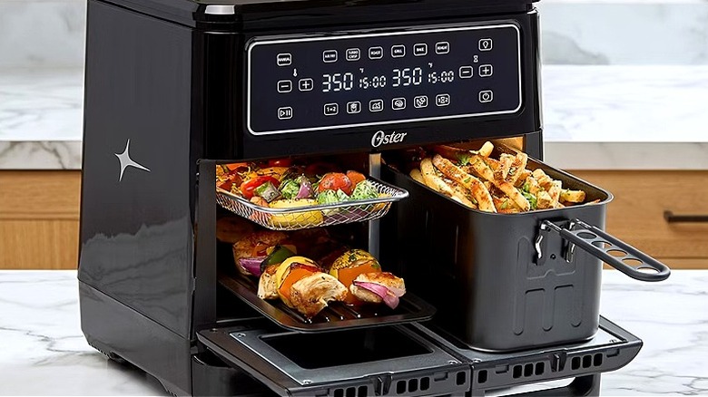 An air fryer on a kitchen island is brimming with food