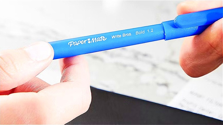 Close-up of a blue pen exchanging hands
