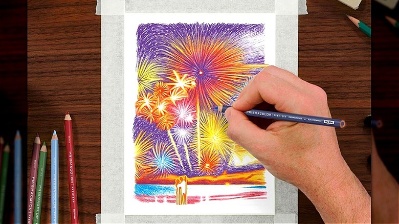 Close-up of a person's hand gripping a color pencil to make a fireworks drawing pop