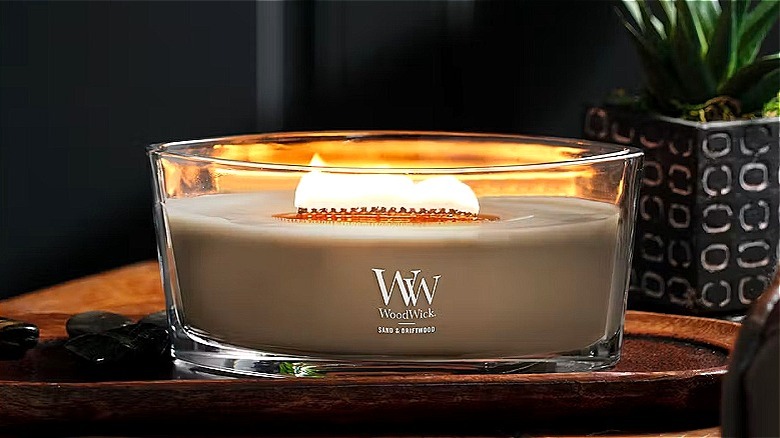 A lit ellipse candle on a side table