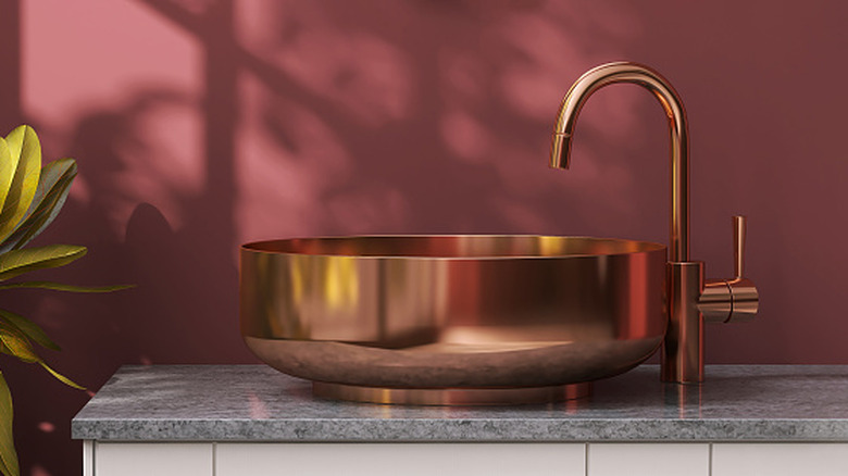 round copper or copper-plated sink on countertop