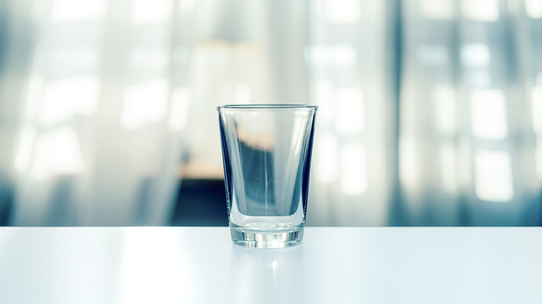 Empty shot glass on table