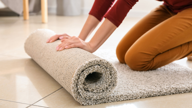 woman rolling up runner rug