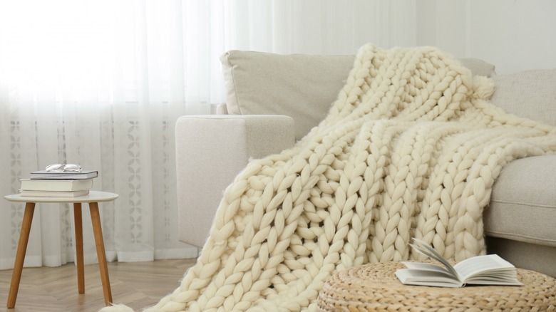 White couch with cream blanket