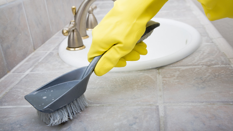 scrubbing tile countertop with brush