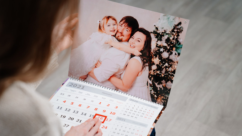 person looking at calendar with family photo