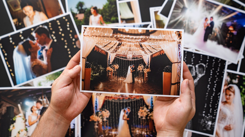 person holding printed wedding photos
