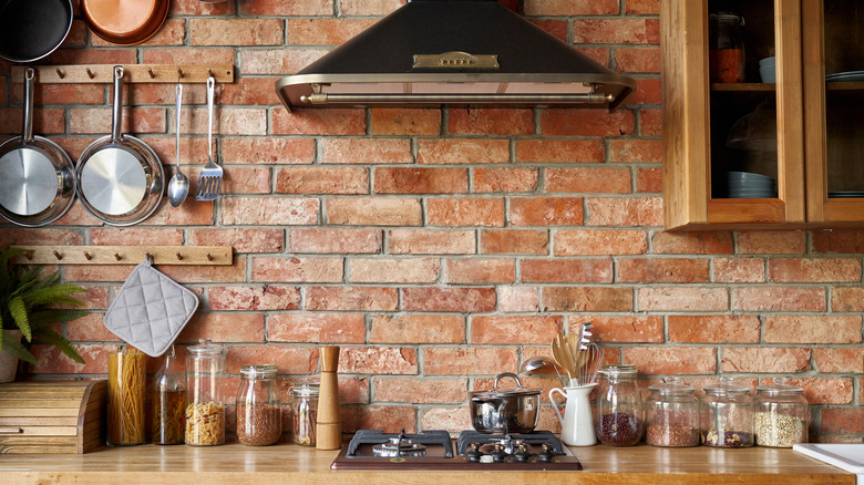 Brick kitchen backsplash with wooden cabinets