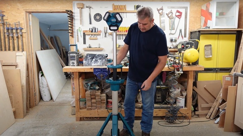 Man working with a Makita tower light in a workshop