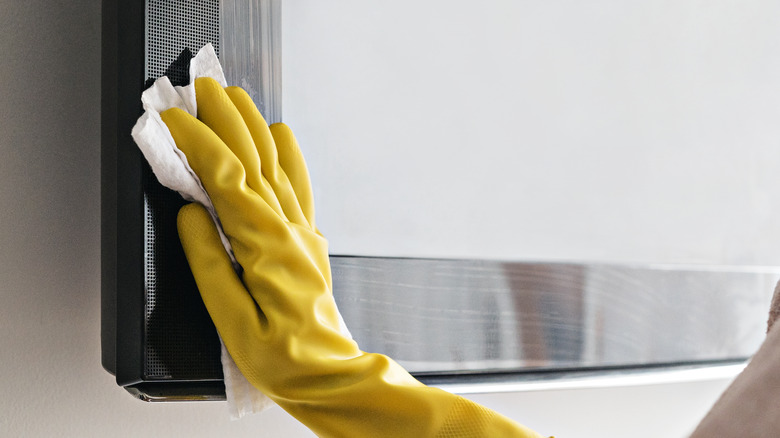person clenaing tv with cloth