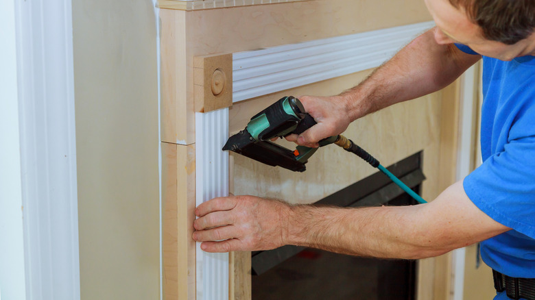 Man installing a fireplace surround during a remodel