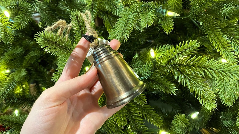 hand holding metal bell ornament