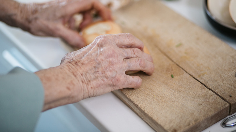 woman uses worn cutting board