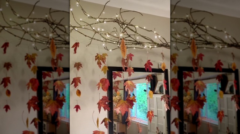 A mobile made from leaves, branches, and string lights