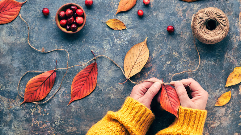 Hands working on a leaf garland