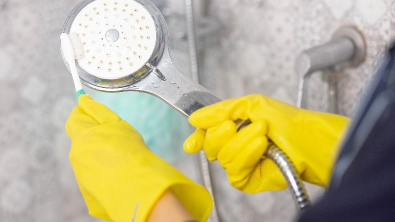 Person brushing shower head