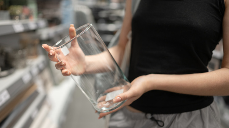 girl holding glass vase in craft store