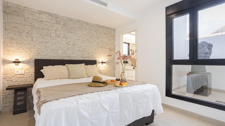 Light-colored stone accent wall in modern bedroom