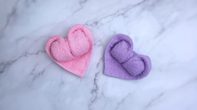 pink and purple bath towels folded into heart shapes