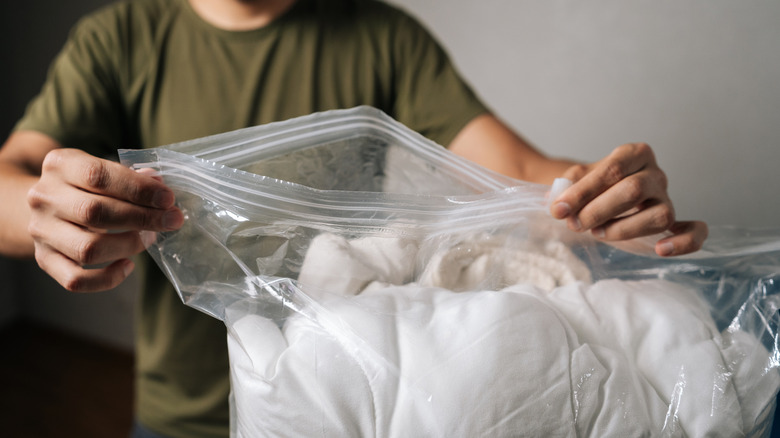Close up of person putting duvet into sealed bag