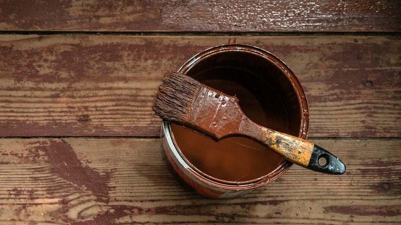 Dirty paintbrush resting on can