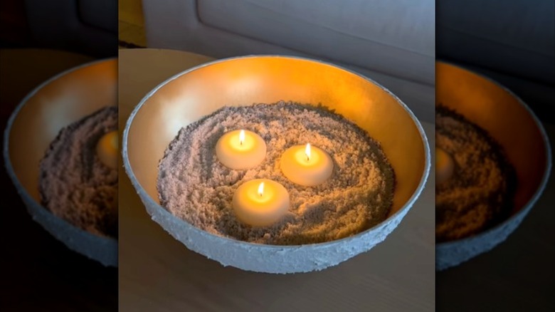 A budget-friendly DIY candle display from a gold painted bowl, sand and textured outer layer