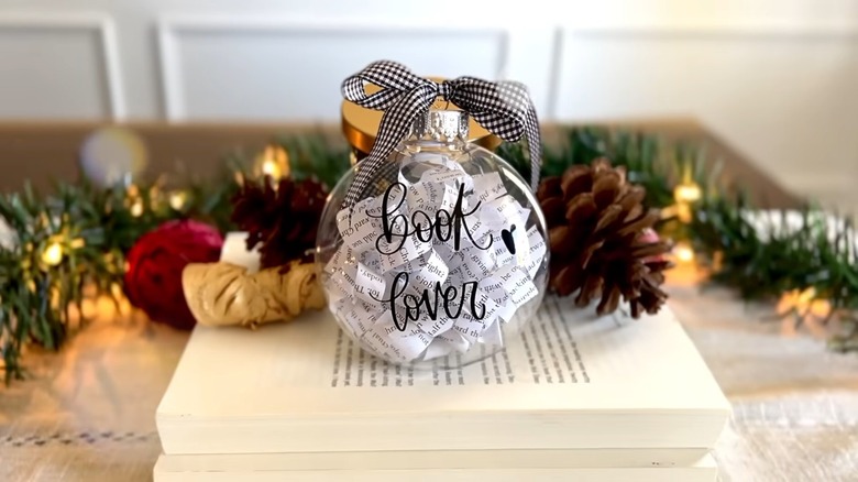 A clear Christmas ornament with book strips inside