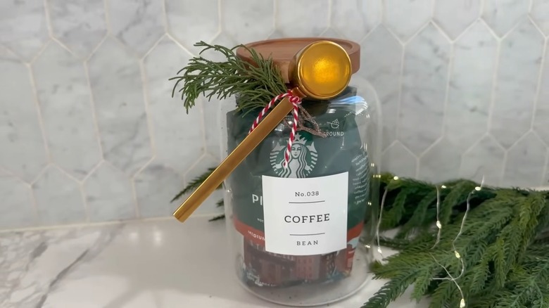 A glass jar with a bag of coffee grounds inside