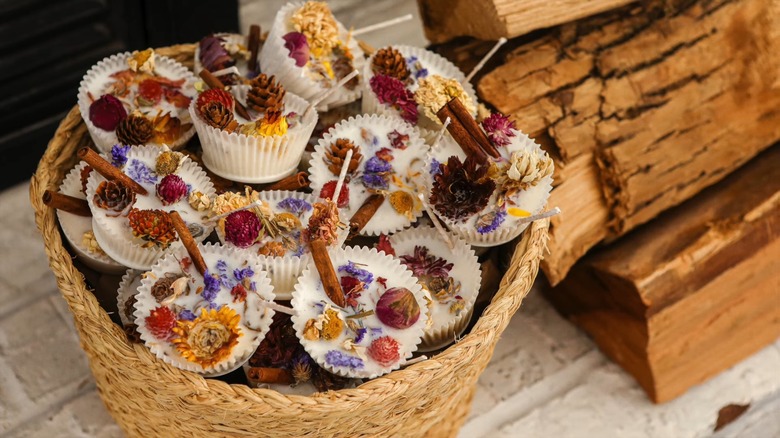 Homemade fire starters in a woven basket by some chopped wood