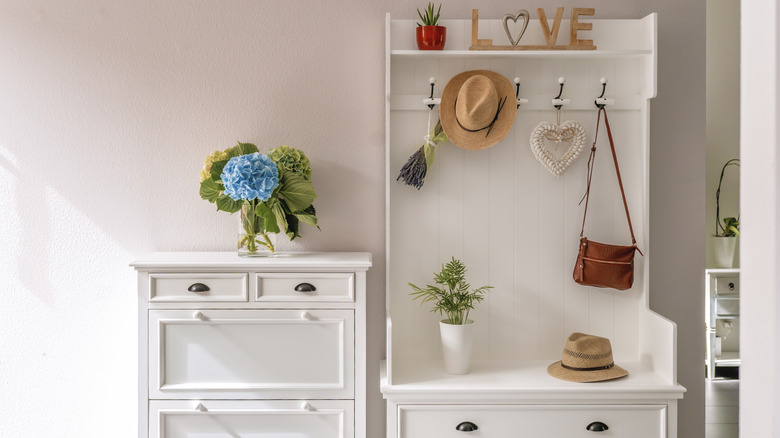 Entryway with a white hall tree beside a white accent cabinet.
