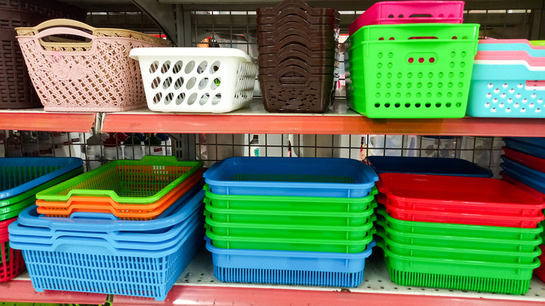 Store shelves lined with stacks of different colored plastic crates and baskets.