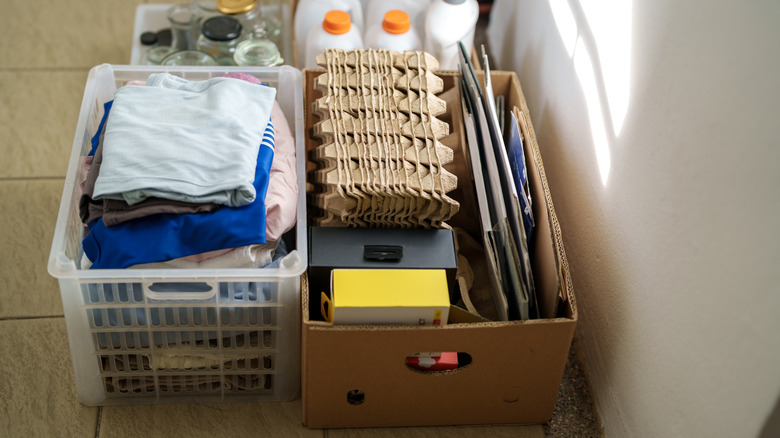 A cardboard box with handle cutouts used to store recyclable materials.
